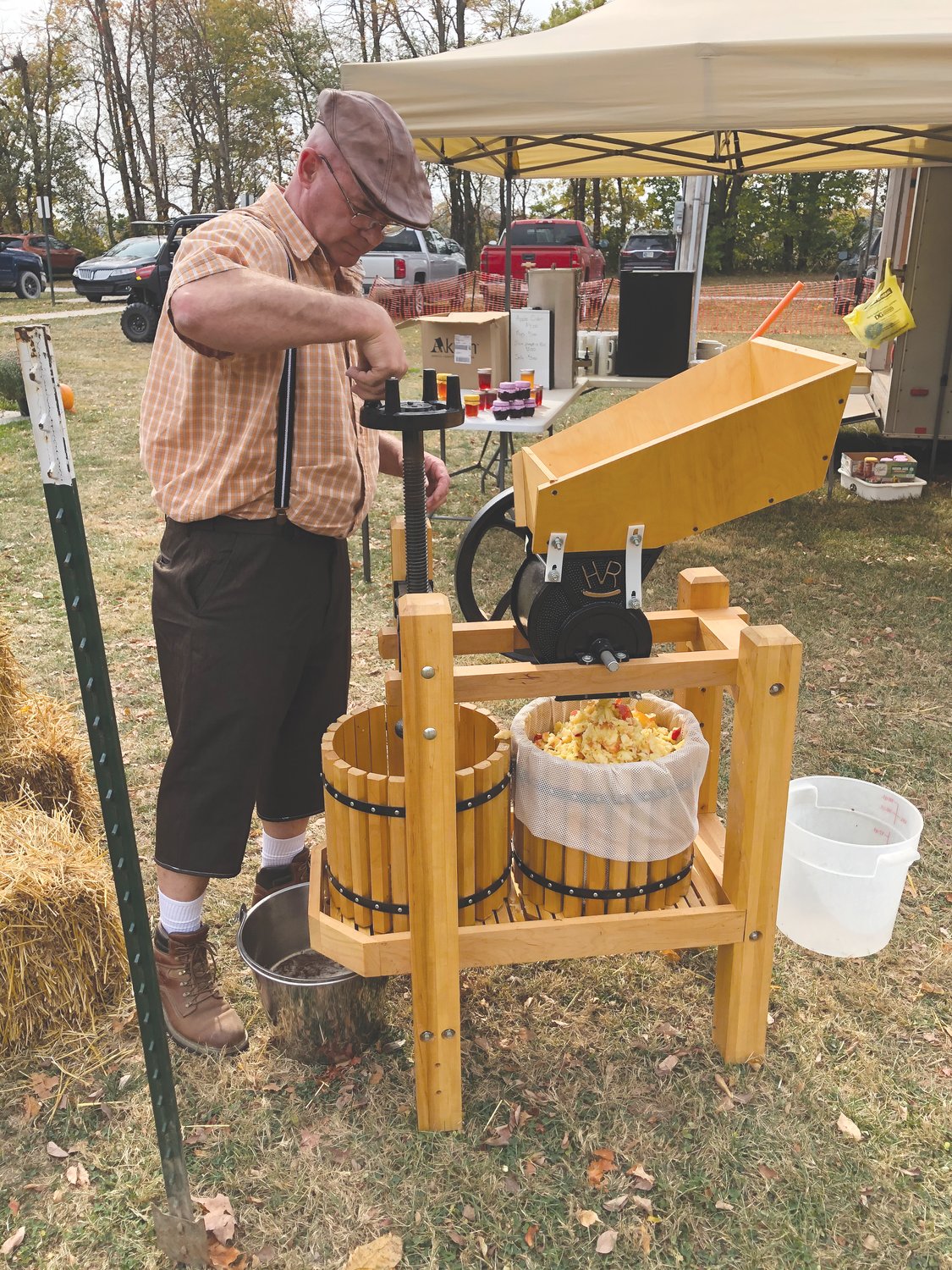 Phil Pirtle uses a press to make fresh apple cider on Saturday at the Waynetown Oktoberfest.